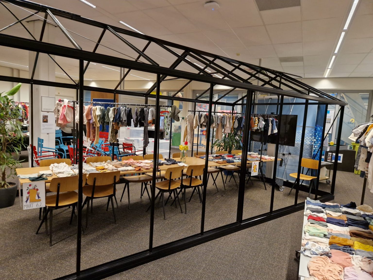 Racks and tables with children's clothes inside the NHL Stenden Experience Center.